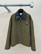Olive textured jacket with dark blue pointed collar and front zipper closure