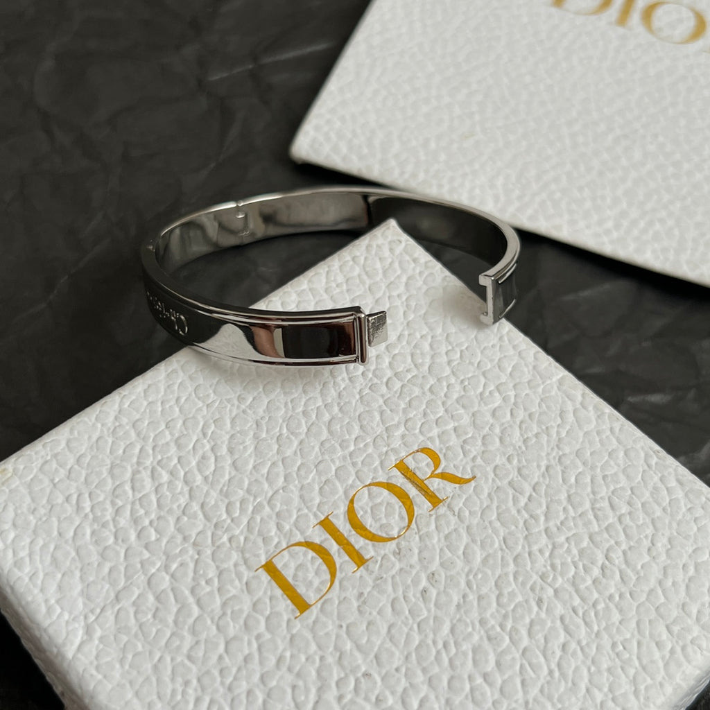 Silver-tone cuff bracelet with black textured band and buckle detail