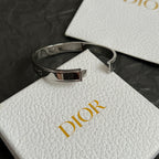 Silver-tone cuff bracelet with black textured band and buckle detail