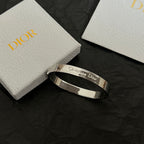 Silver-tone cuff bracelet with Christian Dior engraving and smooth wide profile