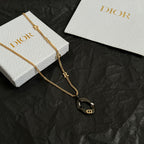 Gold-tone Dior charm necklace with black heart pendant and letter R detail