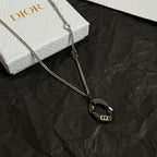 Dior charm necklace with silver-tone chain and dark oval logo pendant