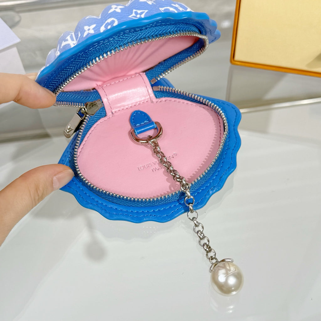 Small monogram pouch bag with pink interior, blue zipper trim, and chain key charm
