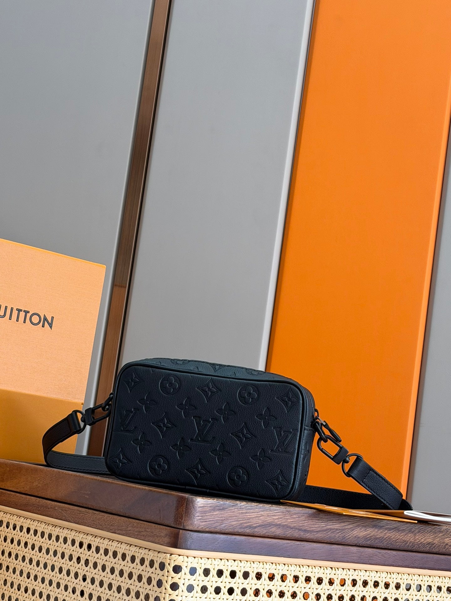 Men's Louis Vuitton monogram crossbody bag with front embossing and strap attachment.