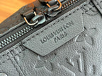 Louis Vuitton bag zipper pull and embossed logo patch on grained dark leather.