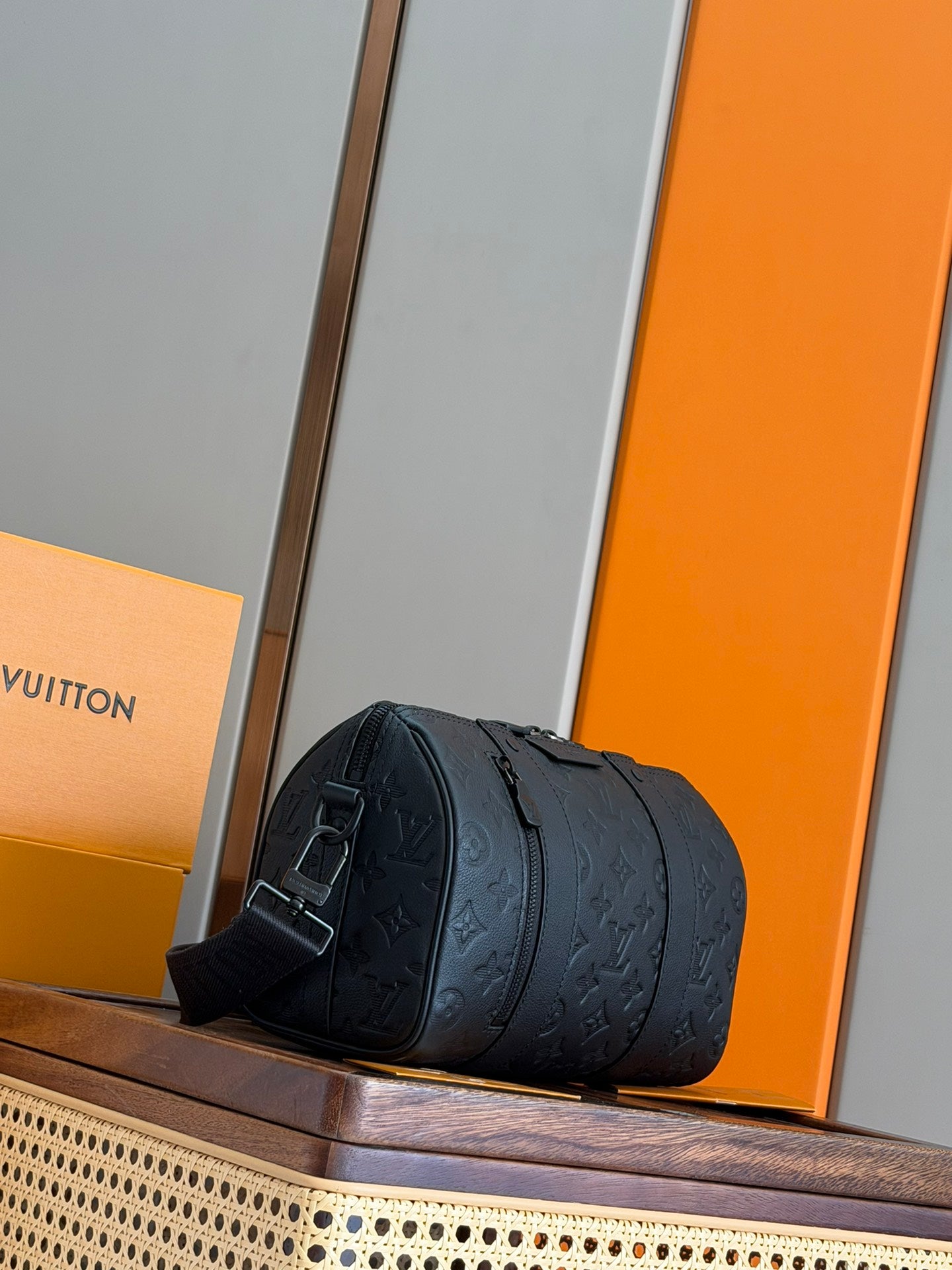 Men's Louis Vuitton cylindrical bag in dark blue with embossed monogram and adjustable strap.