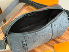 Louis Vuitton bag with zippered opening and embossed monogram on dark gray-blue exterior.
