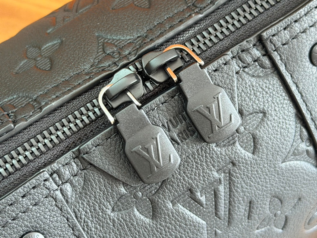 Louis Vuitton bag zipper track with embossed monogram motifs and metal zipper tabs.