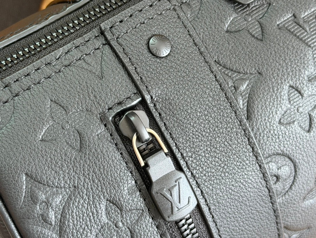 Louis Vuitton bag zipper detail with embossed monogram puller on textured leather.