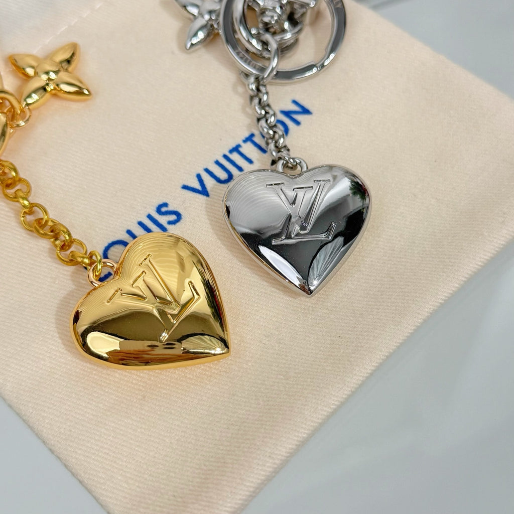 Louis Vuitton small bag charm keychain with two heart pendants in gold and silver