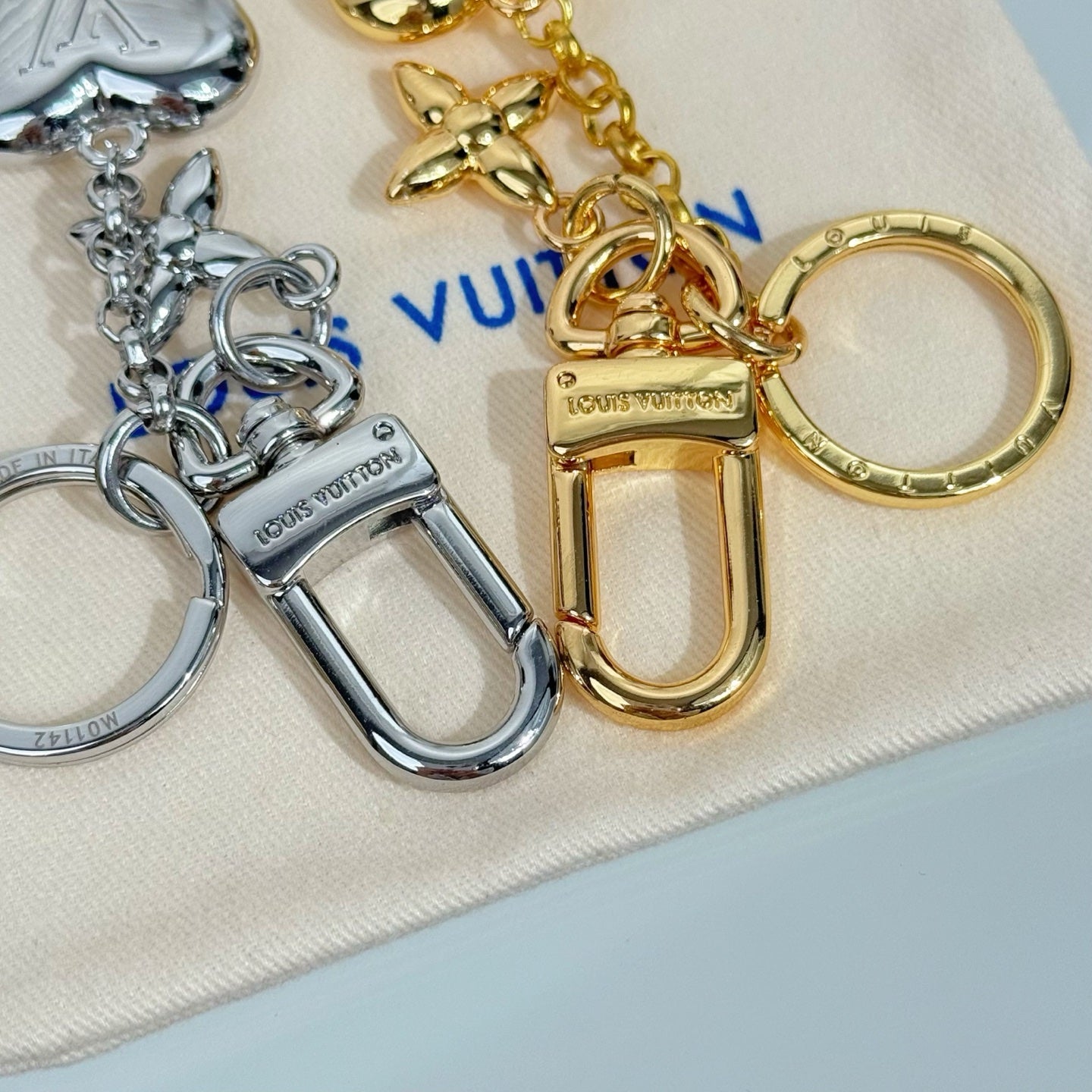 Louis Vuitton small bag charm keychain with gold lock, chain links, and silver heart