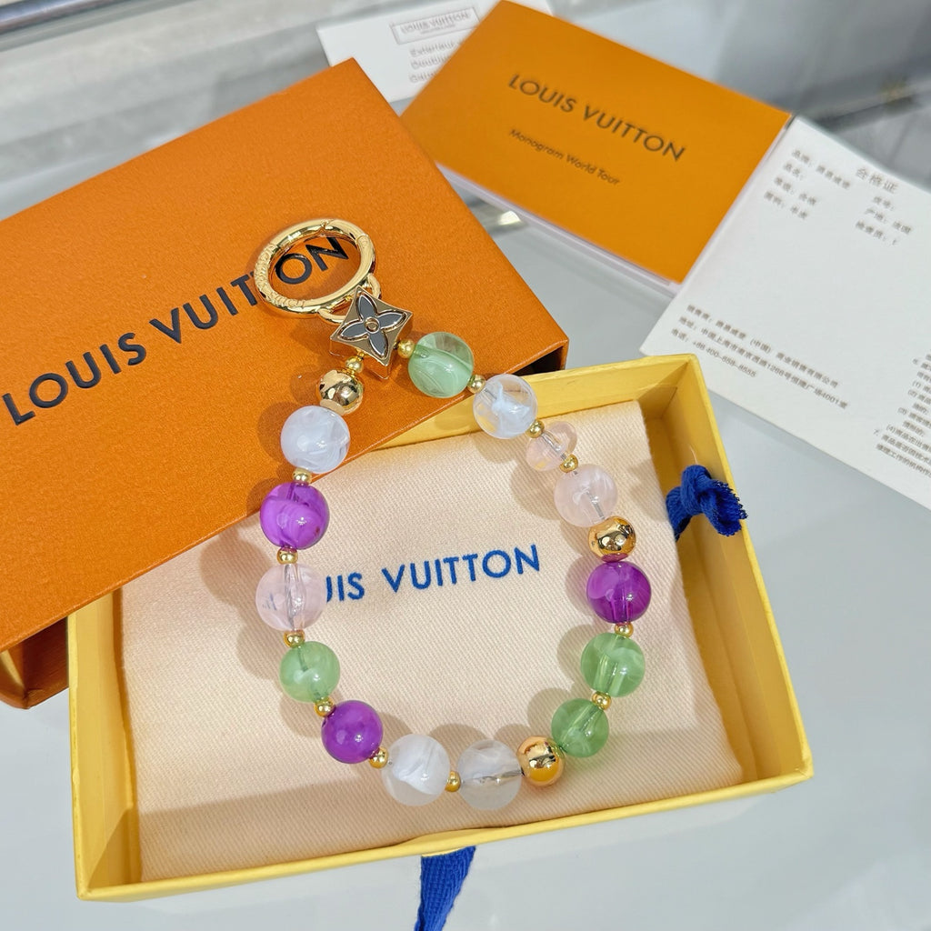 Beaded charm bracelet in box with gold ring, multicolor beads, and blue tassel
