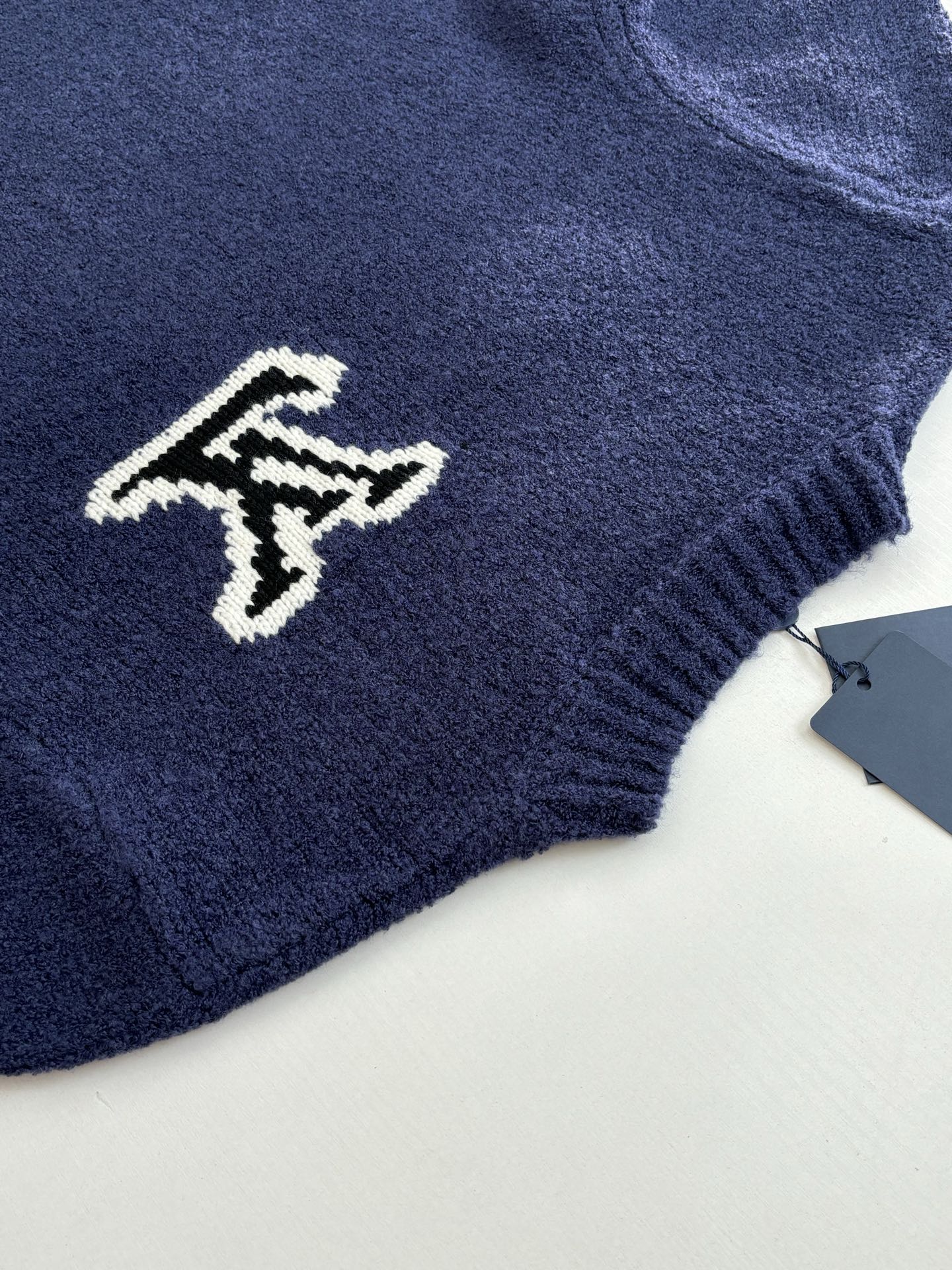 Louis Vuitton knit sweater sleeve with small white LV logo on dark blue