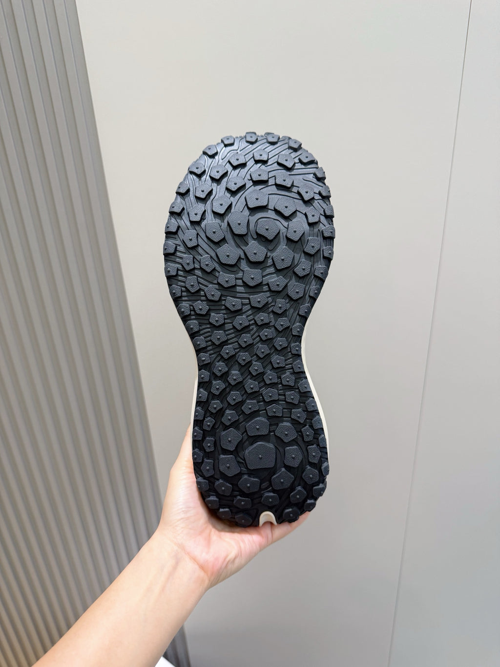 Moncler outsole view, dark rubber tread with circular traction pattern