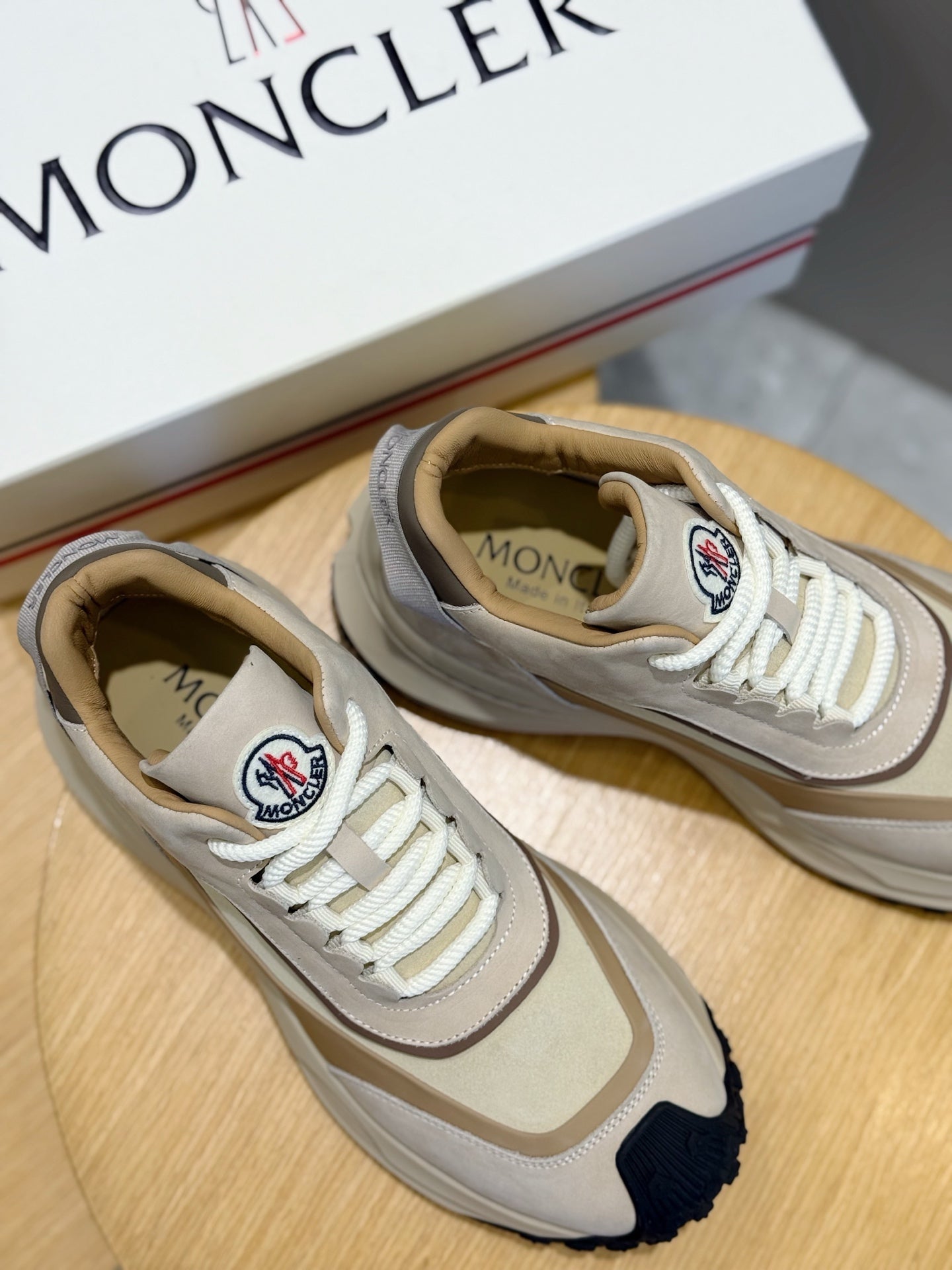 Moncler sneakers close-up, beige leather with logo patch and white lace-up trim