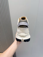 Moncler sneakers heel view, cream upper with MONCLER text and dark sole