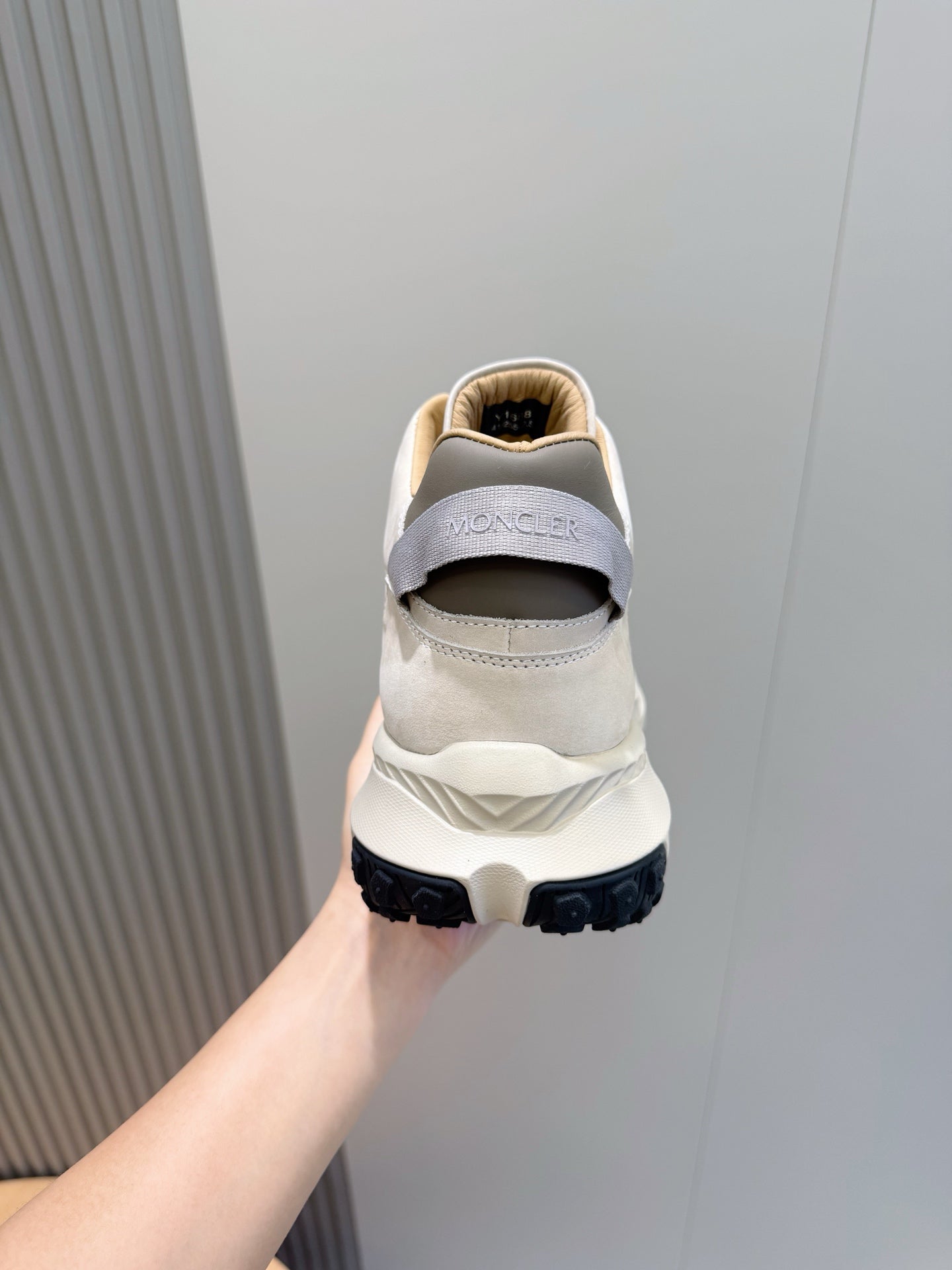 Moncler sneakers heel view, cream upper with MONCLER text and dark sole