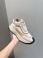 Moncler sneaker held in hand, beige and off-white with white laces and dark outsole