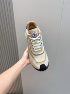 Moncler sneaker held in hand, beige upper with white laces and logo tongue patch