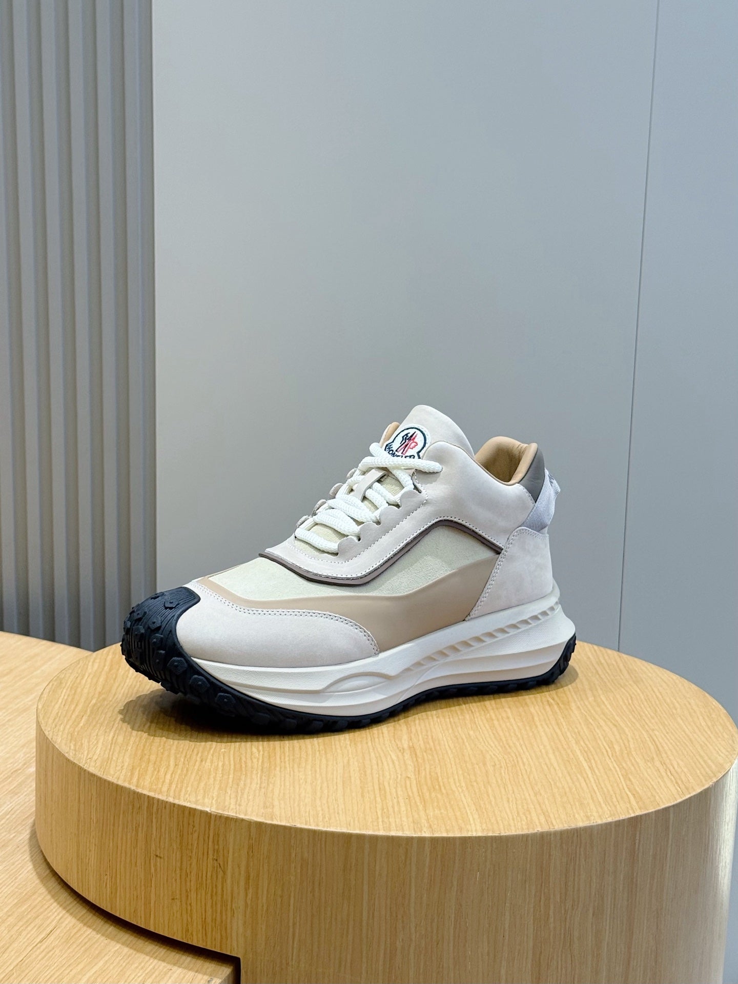 Moncler sneakers on display, cream and beige panels with white laces
