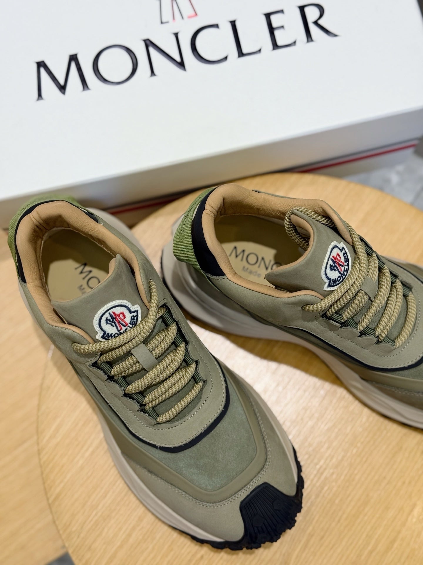Moncler luxury shoes olive green lace-up sneakers side-by-side on display surface