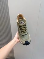 Moncler sneaker held in hand, sage green upper with lace-up closure and navy trim