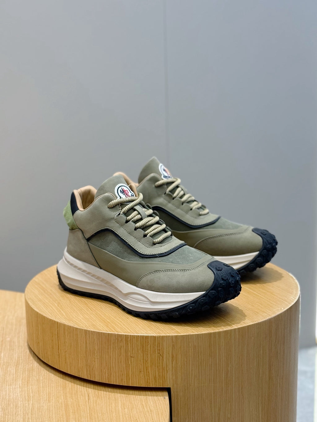 Moncler lace-up sneakers in sage green with white sole and dark navy tread outsole
