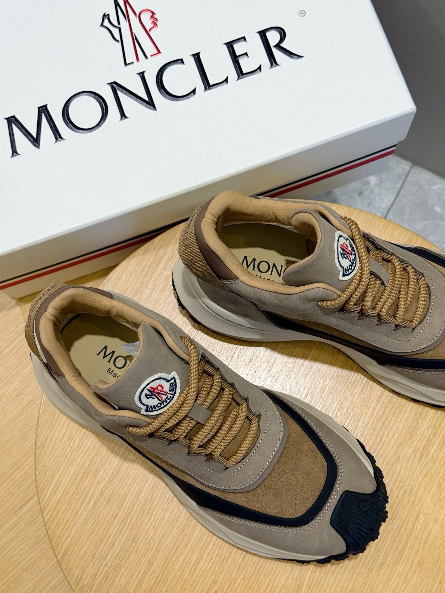 Moncler sneakers on box in beige and navy, lace-up style with side logo patch.