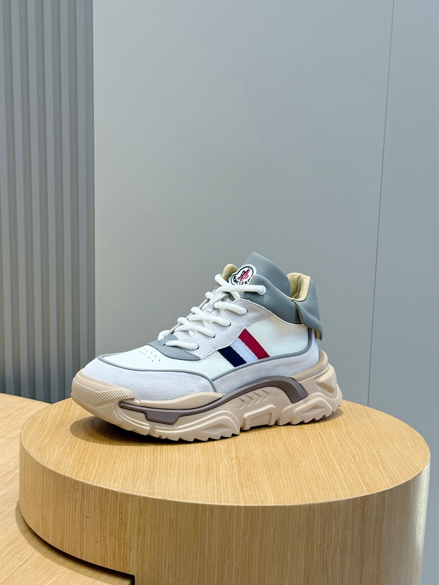 Moncler sneakers on display, light blue upper with red and blue stripe detail