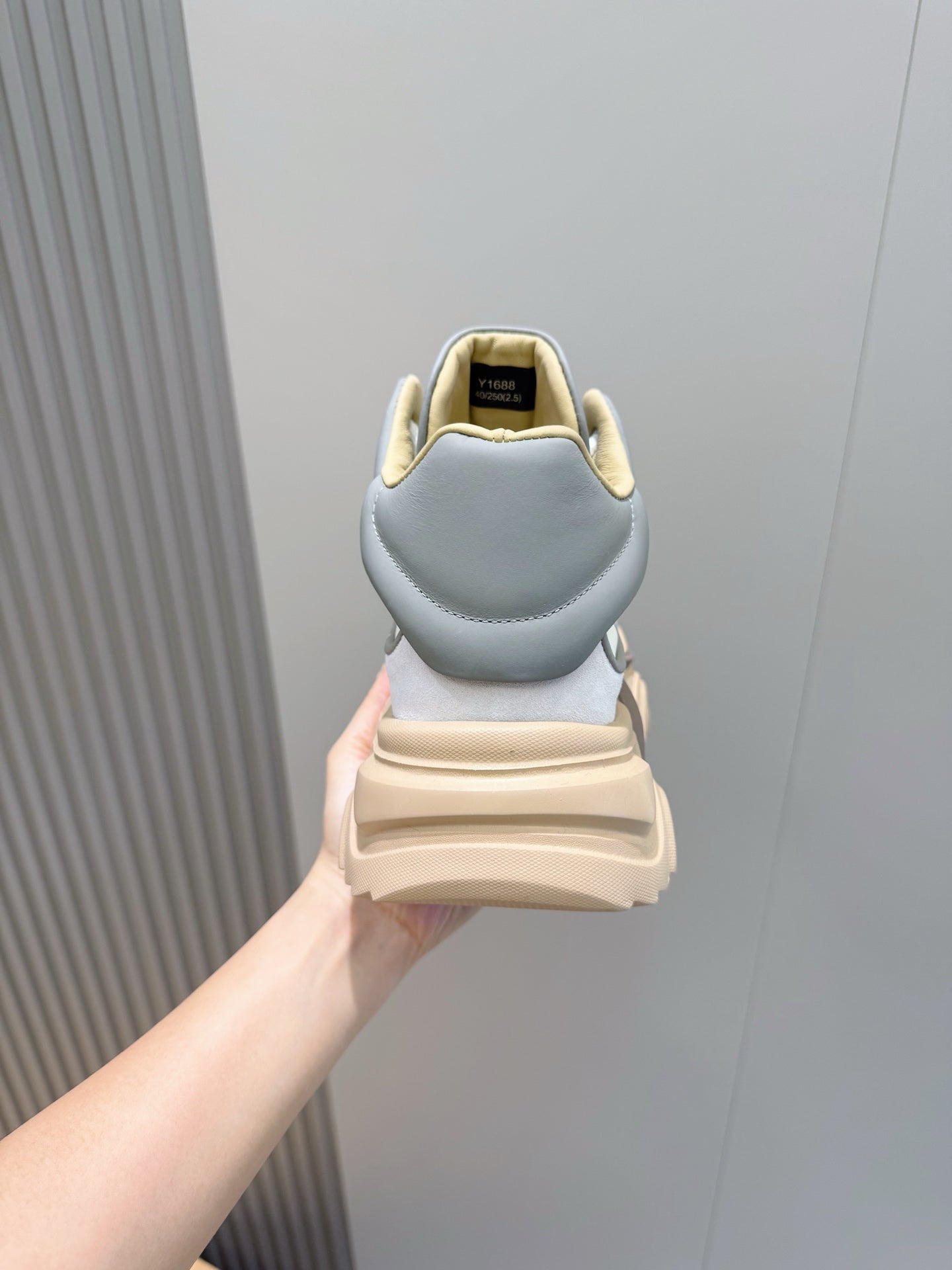 Back view of light blue sneakers with tan sole and heel tab