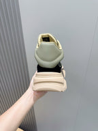 Moncler sneaker heel view held in hand, navy upper with beige lining and sole