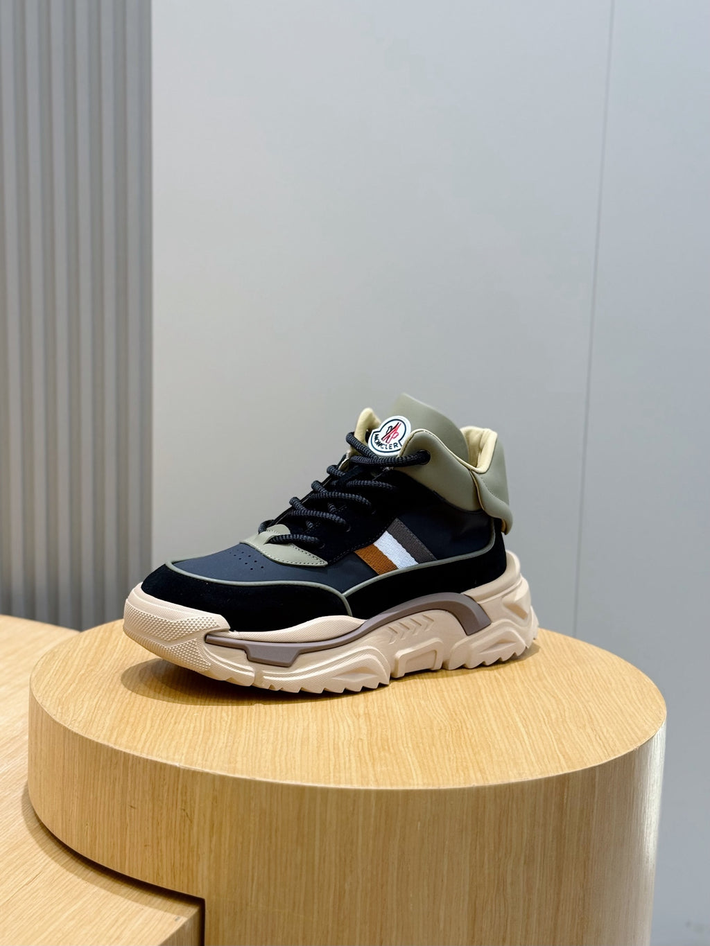Navy lace-up sneakers with tan collar, white stripe, and thick sole