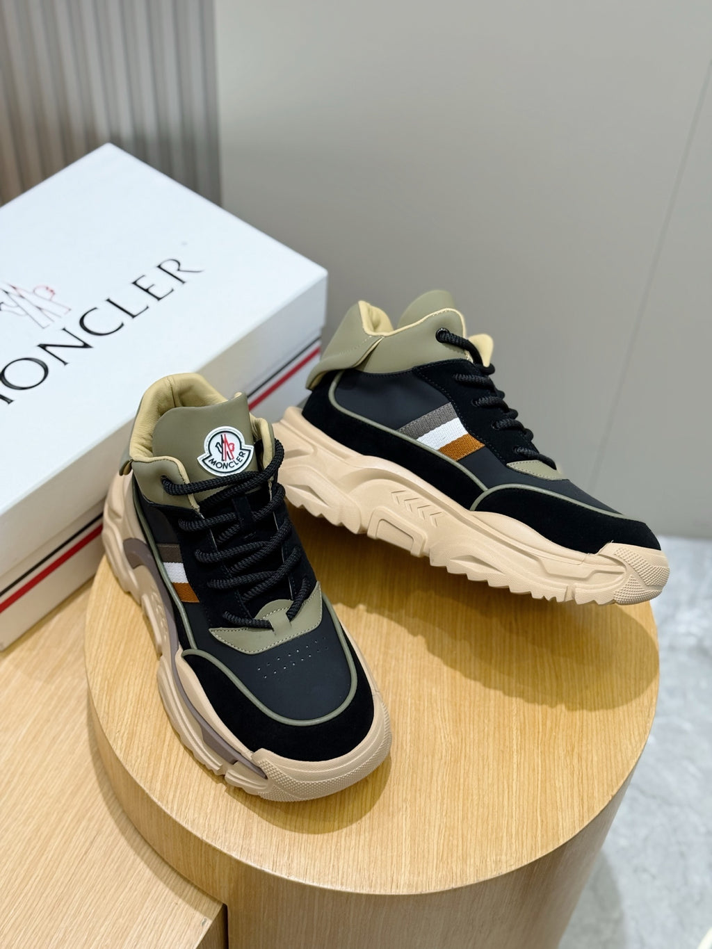 Moncler pair of lace-up sneakers on round display, navy with beige accents