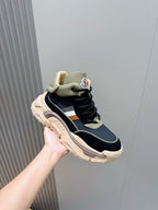 Moncler lace-up sneakers held in hand, navy upper with beige heel and chunky sole