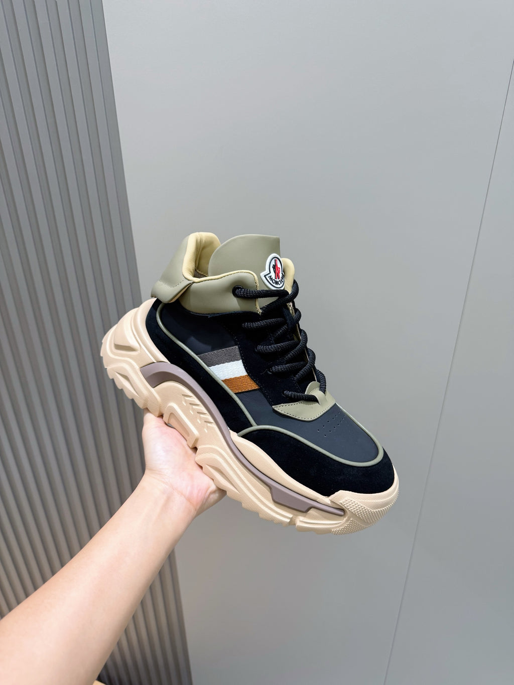 Side view of navy lace-up sneakers with beige trim, white stripe, and thick sole