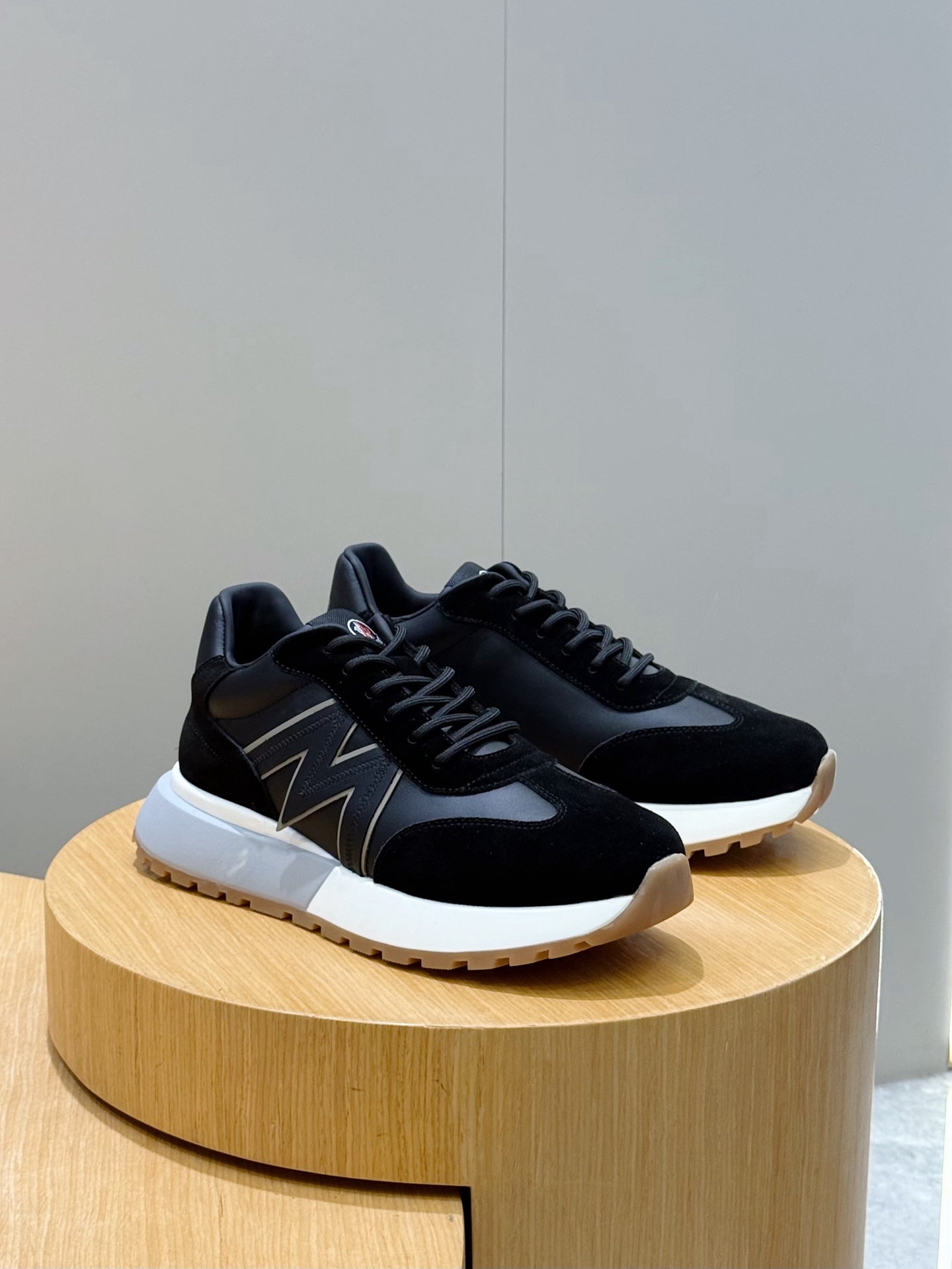 Black sneakers with zigzag side stripe, black laces, and white outsole