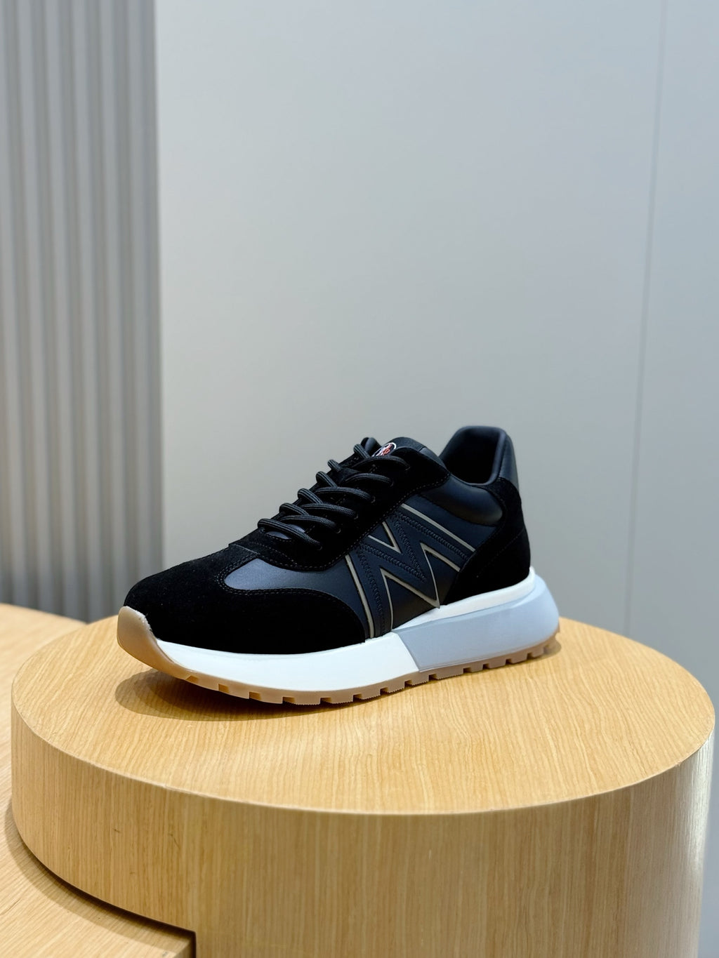 Black low-top sneakers with zigzag side stripe, black laces, and white sole