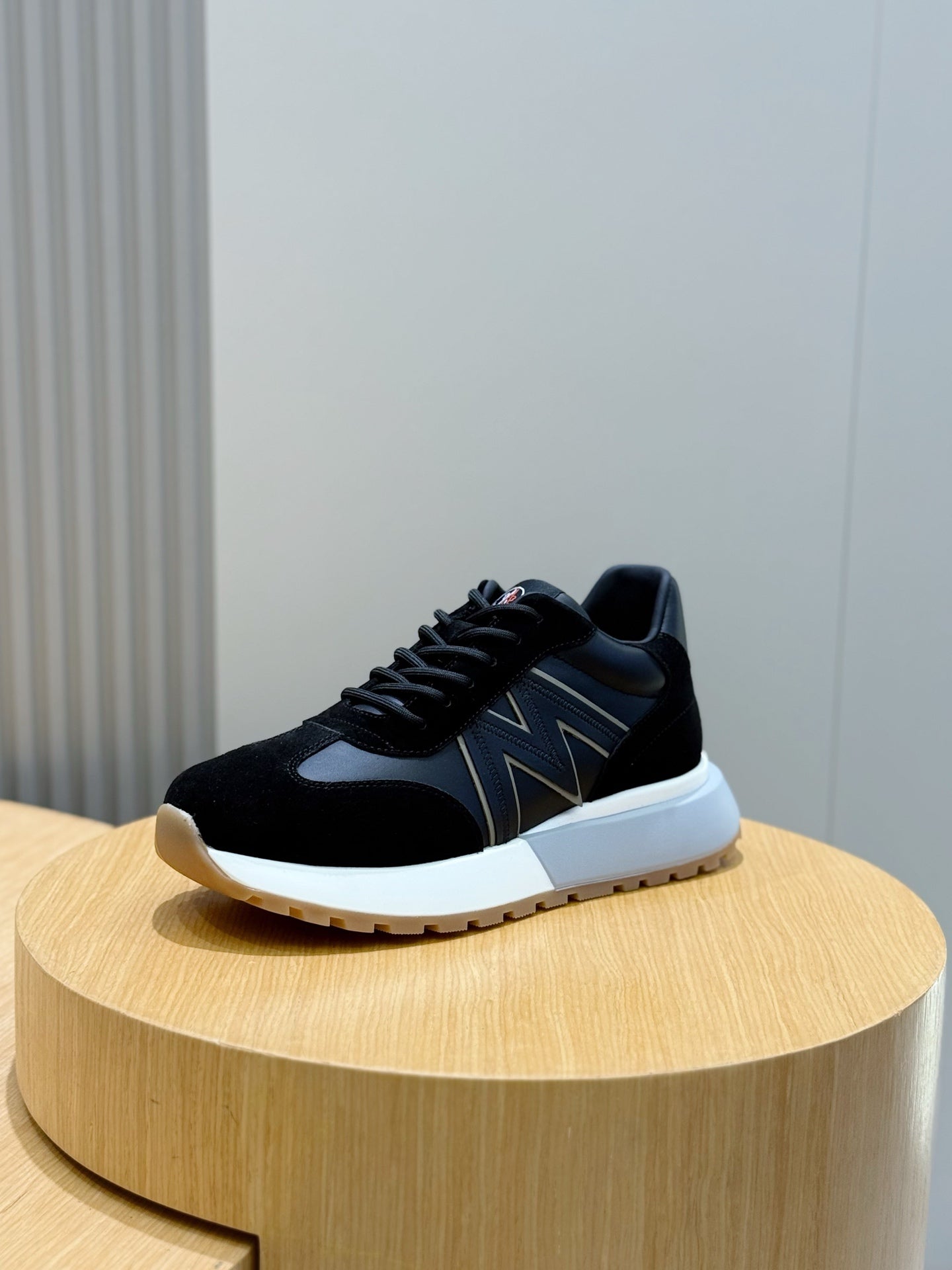 Black low-top sneakers with zigzag side stripe, black laces, and white sole