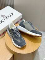 Pair of dark blue suede lace-up sneakers with gray N logo on the sides