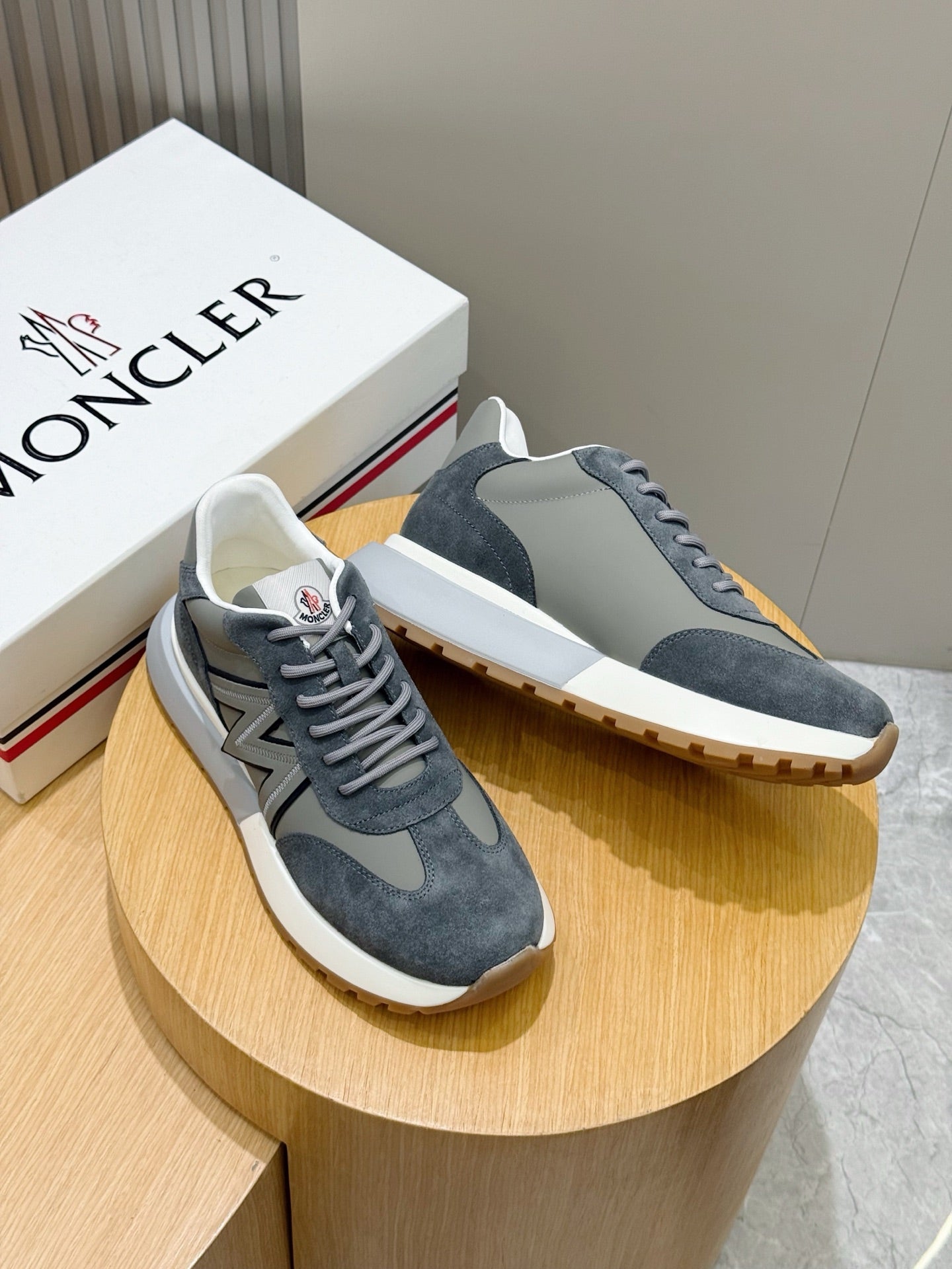 Pair of dark blue suede lace-up sneakers with gray N logo on the sides