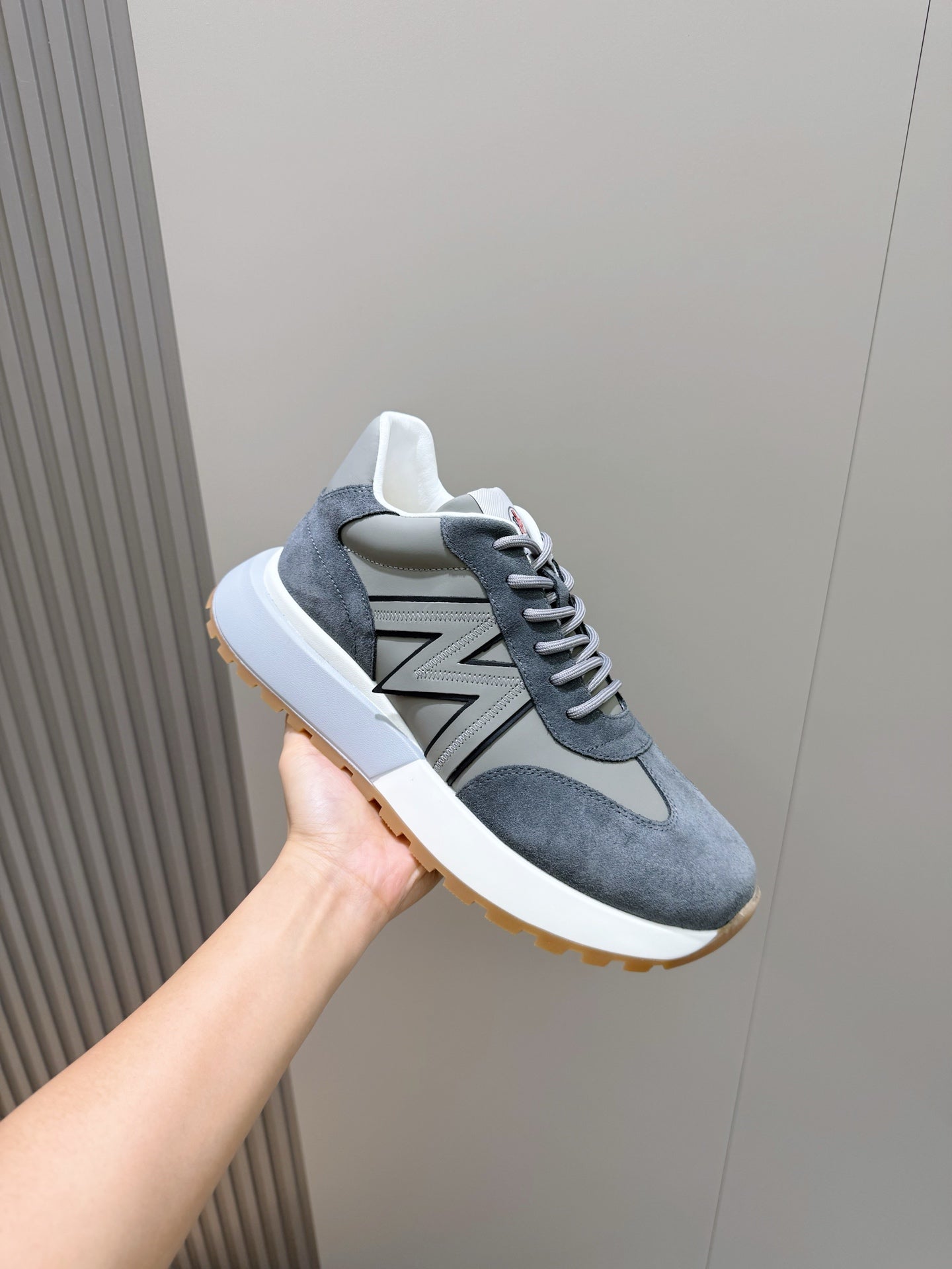 Dark blue suede lace-up sneakers with gray N logo and white sole with gum edge