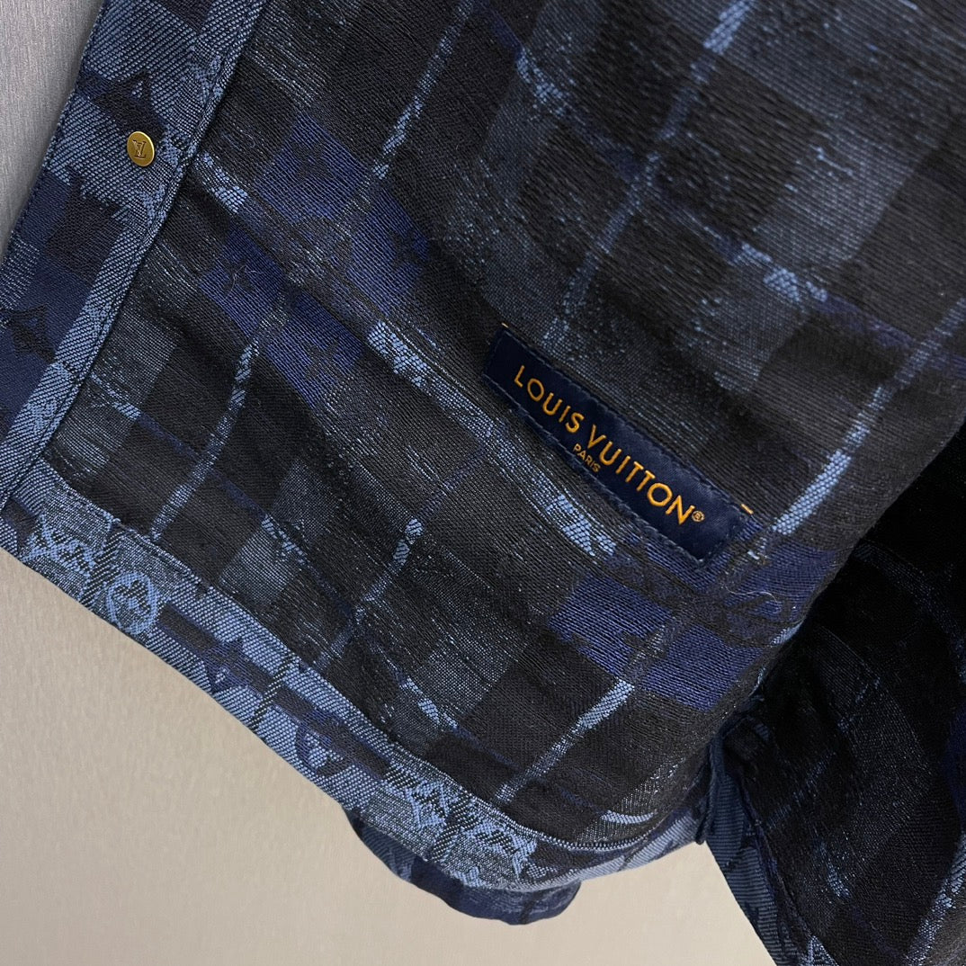 Louis Vuitton logo tag on blue patterned fabric, stitched near seam