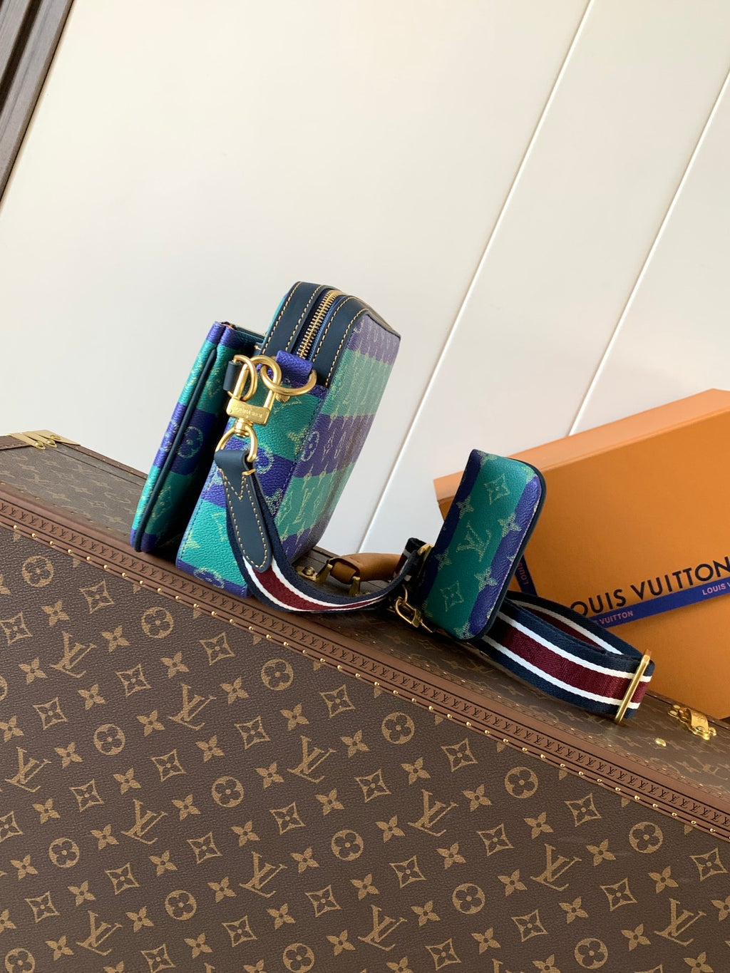 Louis Vuitton men’s crossbody bag with striped strap and side view of zippers