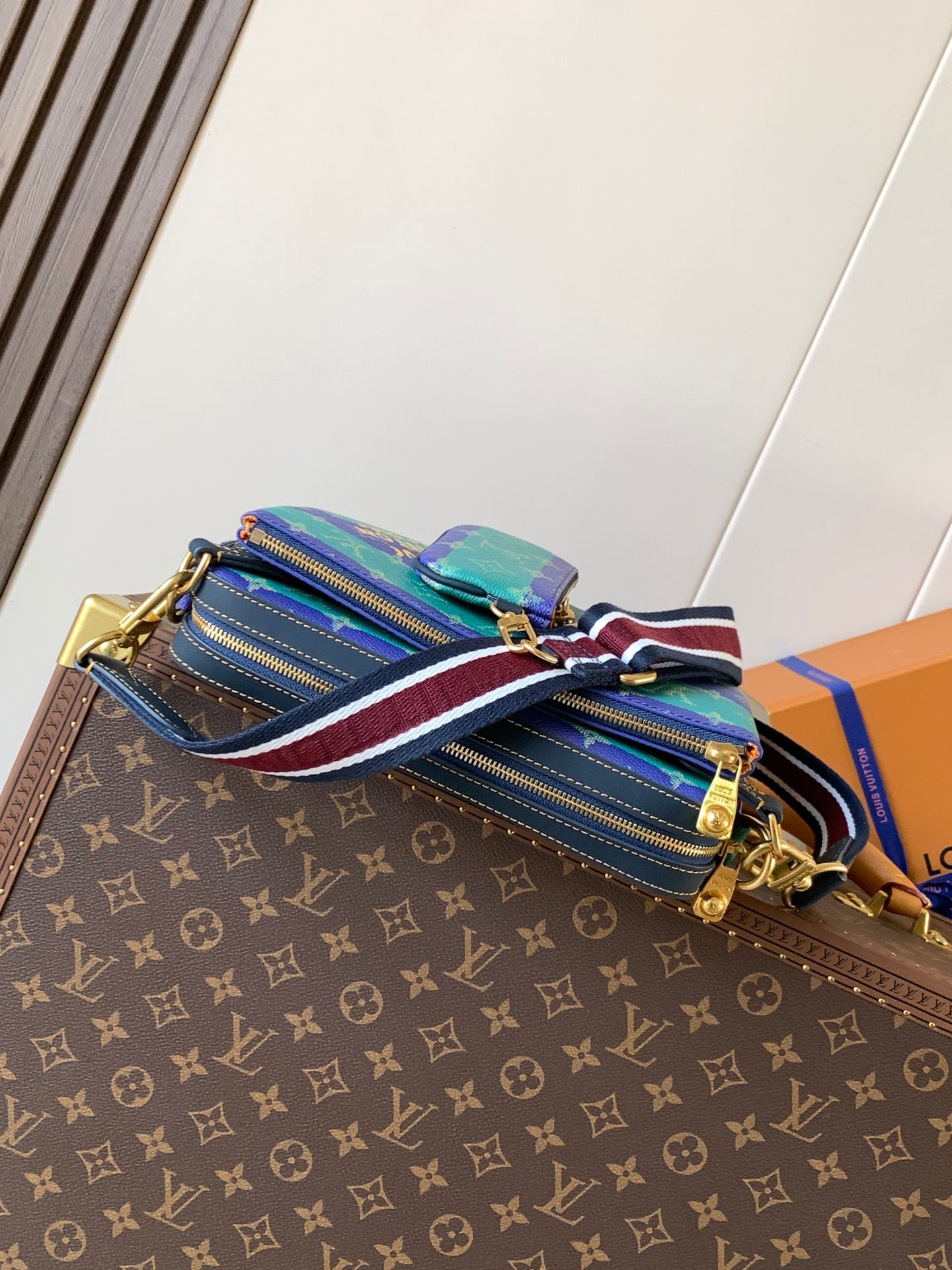 Louis Vuitton men’s crossbody bag with multiple zipper panels and striped strap
