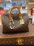 Louis Vuitton monogram small handbag with tan handles and hanging beaded charm, with tag