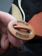 Leather logo patch with MONCLER and GRENOBLE text on jacket drawcord