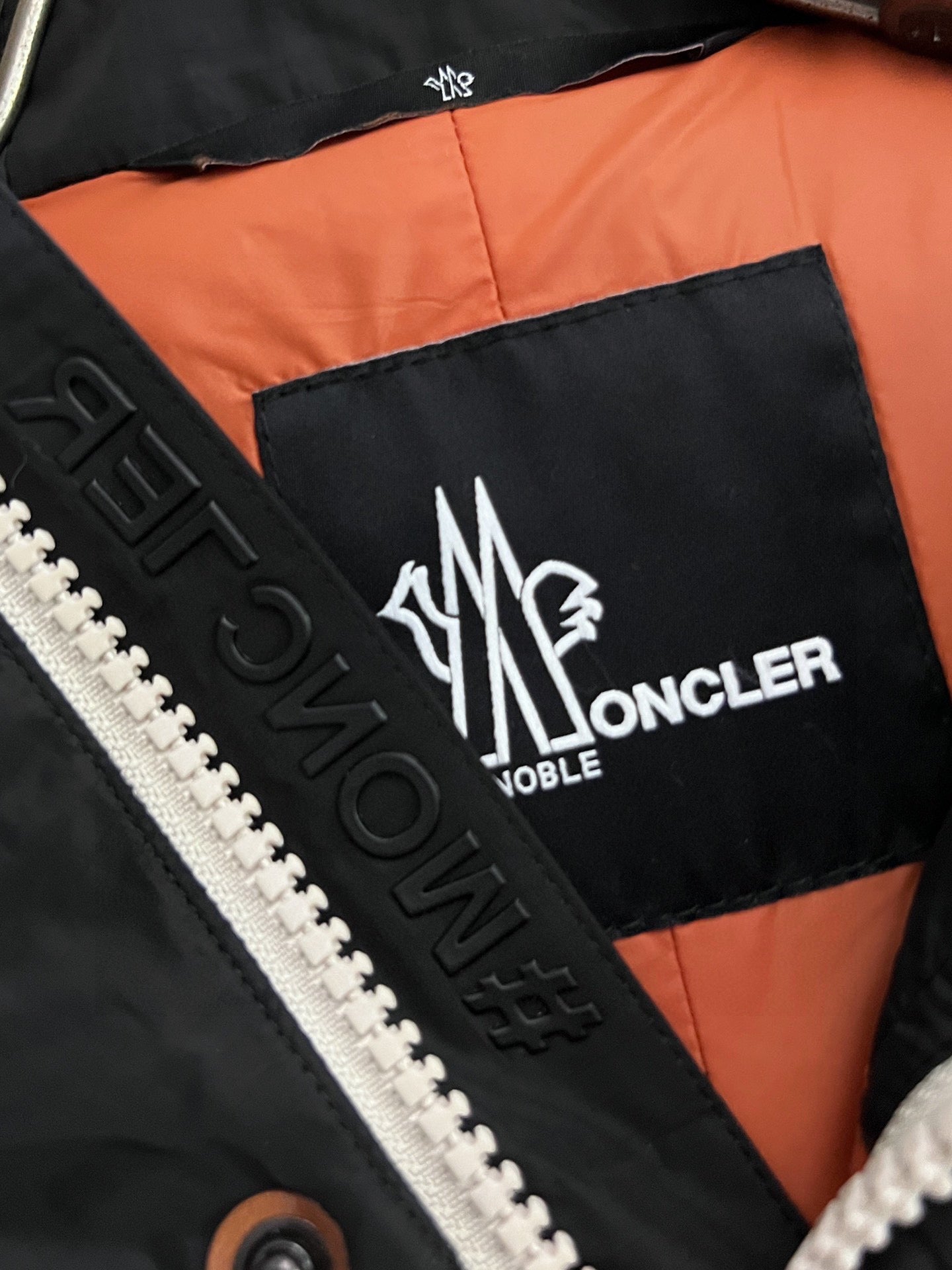 Logo label on black and orange jacket lining with MONCLER lettering