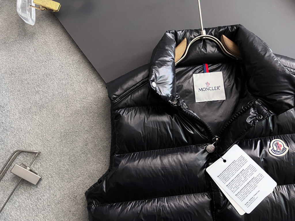 Long black puffer jacket with hood and front snap placket, brand tag visible