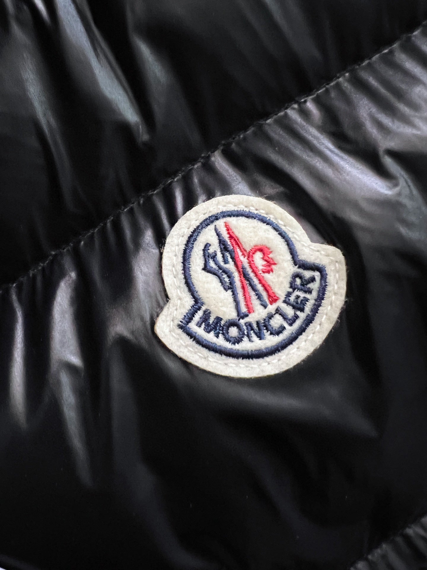 Circular logo patch on black puffer jacket sleeve