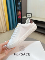White Versace low-top sneakers with brown interior lining and embossed Greek-motif sole